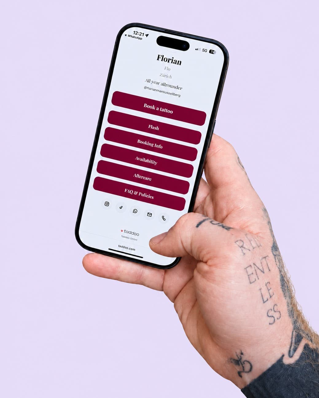Tattoo artist Florian holding his phone with his link in bio page on Taddoo