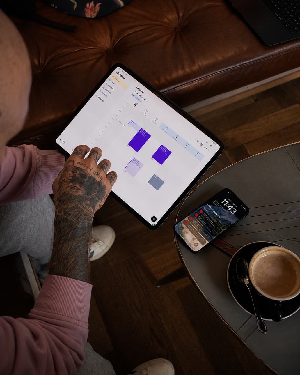 Tattoo artist tapping the Taddoo calendar on an iPad in a café